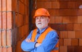 Portrait serious handsome builder in hard hat working on house construction. Male engineer or architect at building site Royalty Free Stock Photo