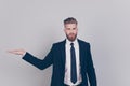 Portrait of serious handsome confident strict professional expert with red beard wearing black formal outfit dark blazer