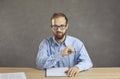 Portrait of serious hiring manager in glasses sitting at office desk during job interview