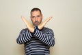 Portrait of serious Hispanic man with hands crossed, showing x sign which means stop, warning of trouble. Isolated on