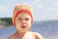 Portrait of serious little girl in hat on summer beach looking at camera Royalty Free Stock Photo