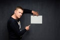 Portrait of serious man holding paper sheet and pointing at it Royalty Free Stock Photo