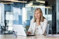 Portrait of serious mature thinking businesswoman, gray haired female boss looking at camera, at workplace inside office