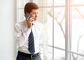 Portrait of serious men office worker talking on mobile phone while standing in modern office Royalty Free Stock Photo
