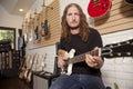 Portrait of serious mid adult man sitting in guitar store