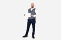 Portrait of serious middle-aged man wearing grey checkered vest, blue jeans, white shirt holding blank sheet of paper. Royalty Free Stock Photo