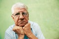 Portrait of serious old man looking at camera with hands on chin Royalty Free Stock Photo