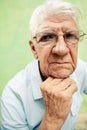 Portrait of serious old man looking at camera with hands on chin Royalty Free Stock Photo