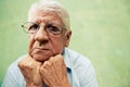 Portrait of serious old man looking at camera with hands on chin Royalty Free Stock Photo