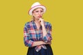 Portrait of serious pensive modern stylish mature woman in casual style with hat and eyeglasses standing, looking away and Royalty Free Stock Photo
