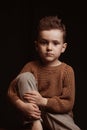 Portrait of serious sad stylish white caucasian child boy kid preschooler a chair Royalty Free Stock Photo