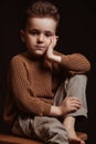 Portrait of serious sad stylish white caucasian child boy kid preschooler a chair Royalty Free Stock Photo