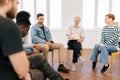 Portrait of serious senior adult male group leader speaking on teambuilding meeting. Business team sitting on chairs in Royalty Free Stock Photo