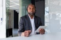 Portrait of a serious senior african man who works in the office in a headset, sits at the table, looks seriously into Royalty Free Stock Photo