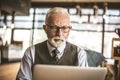 Portrait of serious senior businessman working on laptop. Royalty Free Stock Photo