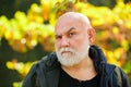 Portrait of serious senior elderly caucasian old man grandfather thinking in the park outdoors. Autumn golden age Royalty Free Stock Photo