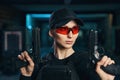 Cute female shooter with two pistols looking away Royalty Free Stock Photo