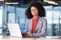 Portrait of a serious and successful African American businesswoman sitting in the office at the desk, working on a Royalty Free Stock Photo