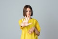 Portrait of a serious teen girl showing stop, ban, block gesture, standing over light grey background. No, Stopping Royalty Free Stock Photo