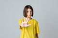 Portrait of a serious teen girl showing stop, ban, block gesture, standing over light grey background. No, Stopping Royalty Free Stock Photo