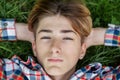 Portrait of serious teenager who lies in grass and rests. Gen Z. Identity development Royalty Free Stock Photo