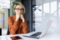 Portrait of a serious thinking woman inside the office at the workplace, business woman looking focused at the camera Royalty Free Stock Photo