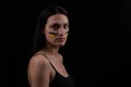 Portrait of serious ukrainian woman with blue and yellow ukrainian flag on her cheek.The symbol of the inviolability of the