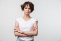 Portrait of serious woman with short brown hair in basic t-shirt frowning and looking at camera Royalty Free Stock Photo