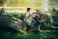 Portrait of serious woman on trunk wood. Young woman posing. Art work of romantic woman. Sensual model girl with smooth Royalty Free Stock Photo