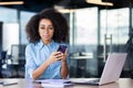 Portrait of a serious young African-American businesswoman working in the office, sitting at a table with a laptop Royalty Free Stock Photo