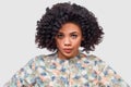 Portrait of serious young African American woman wearing floral shirt, looking to the camera, has frustrated expression, poses in Royalty Free Stock Photo