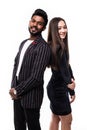 Portrait of a serious young asian couple dressed in formal wear standing back to back over white background Royalty Free Stock Photo