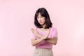 portrait serious young asian woman with cross arm gesture showing stop, no, wrong, denial, rejection sign isolated on pink pastel Royalty Free Stock Photo