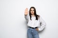 Portrait of a young woman standing with outstretched hand showing stop gesture isolated over white background Royalty Free Stock Photo
