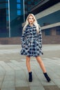 Portrait of serious young blonde model with blue eyes in the coat outdoors Royalty Free Stock Photo