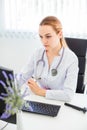 Portrait of a serious young female blonde doctor using a computer in her office Royalty Free Stock Photo