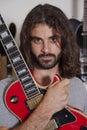 Portrait of serious young musician holding guitar