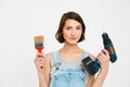 Portrait of serious young pretty girl, holding painting brush Royalty Free Stock Photo