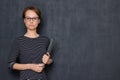 Portrait of serious young woman holding folder and pen in hands Royalty Free Stock Photo