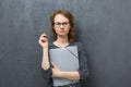 Portrait of serious young woman holding folder and pen Royalty Free Stock Photo