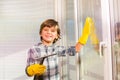 Happy boy washing windows with sponge and brush Royalty Free Stock Photo