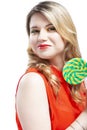 Portrait of Sexy Alluring Caucasian Blond Girl Eating Round Lollipop on Stick. Curious Look. Posing in Studio Against White