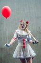 Portrait of sexy bad girl posing with red balloon at the geek cosplay convention