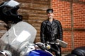 Sexy biker in black leather standing by his motorbike Royalty Free Stock Photo