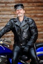 Sexy biker dressed in black leather sitting on his bike