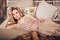 Portrait of a blonde woman in a smart Golden dress lying on the bed and looking at the camera in studio. Luxury girl model, Royalty Free Stock Photo