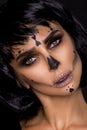 Portrait brunette woman in Halloween makeup on a black background in the studio. Make-up skeleton, monster and witch Royalty Free Stock Photo