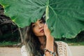 Portrait brunette with palm leaf. Beautiful young woman and big leaf palm Royalty Free Stock Photo