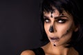 Portrait brunette woman in Halloween makeup on a black background in the studio. Make-up skeleton, monster and witch Royalty Free Stock Photo