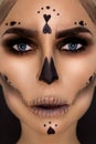 Portrait brunette woman in Halloween makeup on a black background in the studio. Make-up skeleton, monster and witch Royalty Free Stock Photo